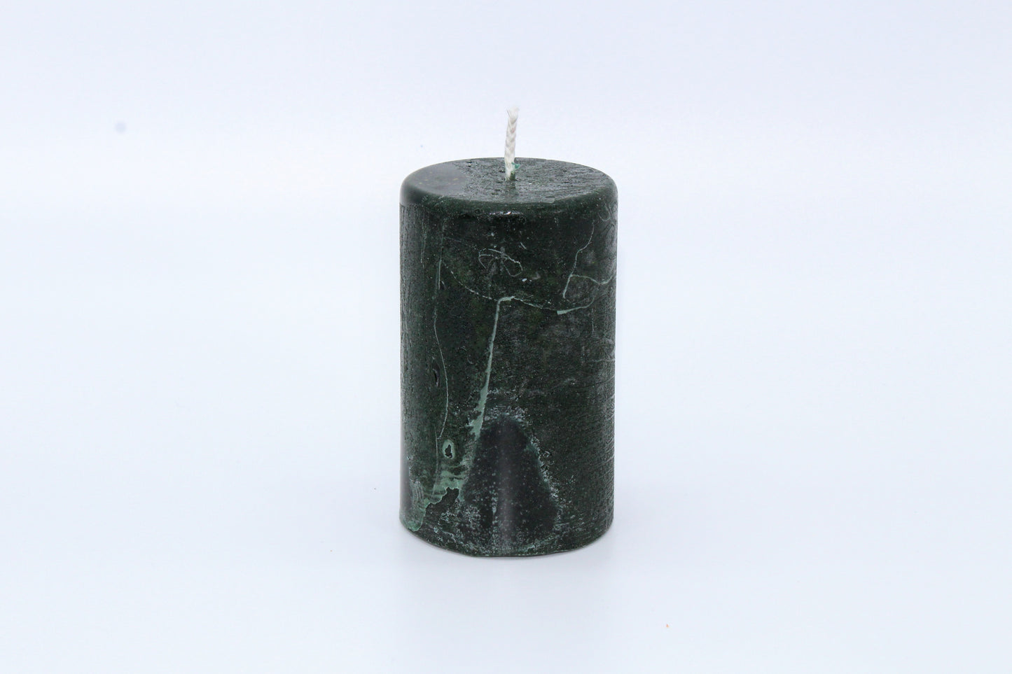 Dark green cylindrical raw effect candle