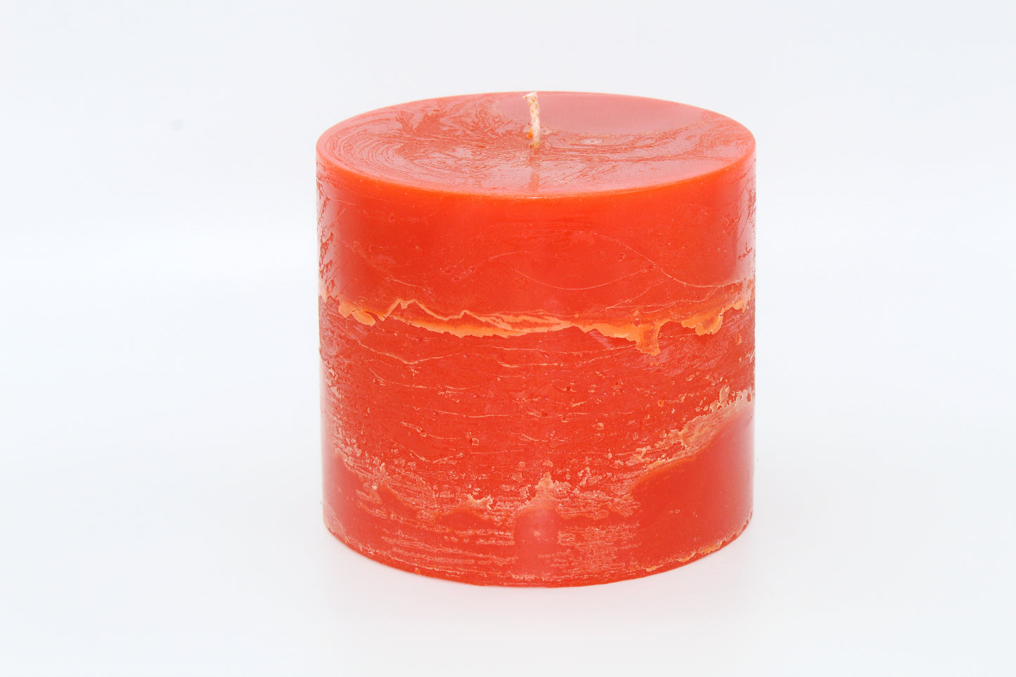 Orangefarbene zylindrische Kerze mit rohem Effekt